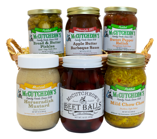 6 jars in a basket including Bread & Butter Pickles, Apple Butter Barbeque Sauce, Sweet Pepper Relish, Horseradish Mustard, Beet Balls, and Mild Chow Chow